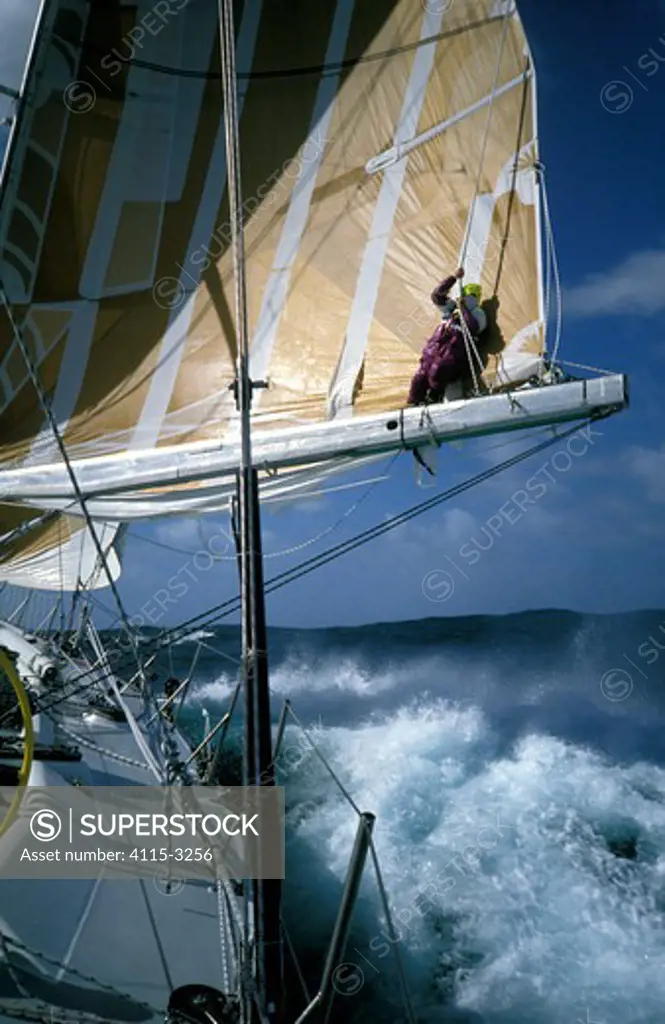 Crewman stands on the boom of 'The Card' as the boat races through the Southern Ocean during the Whitbread Round the World Race, 1989-90.