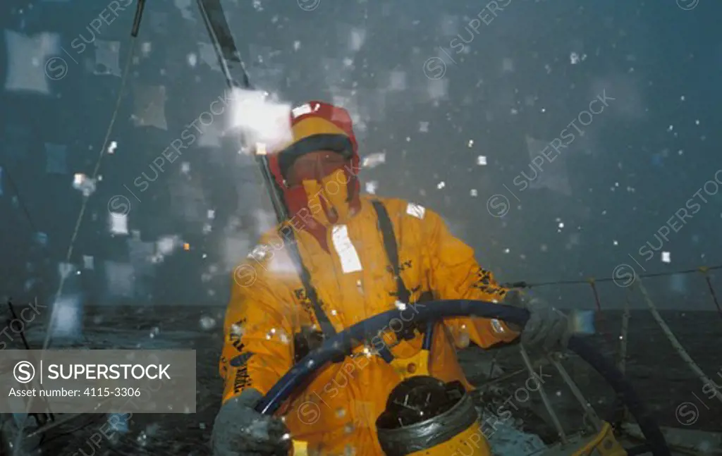 Helmsman in waterproofs as 'Intrum Justitia' passes through the Southern Ocean in the Whitbread Round the World Race, skippered by Lawrie Smith, 1993-94.