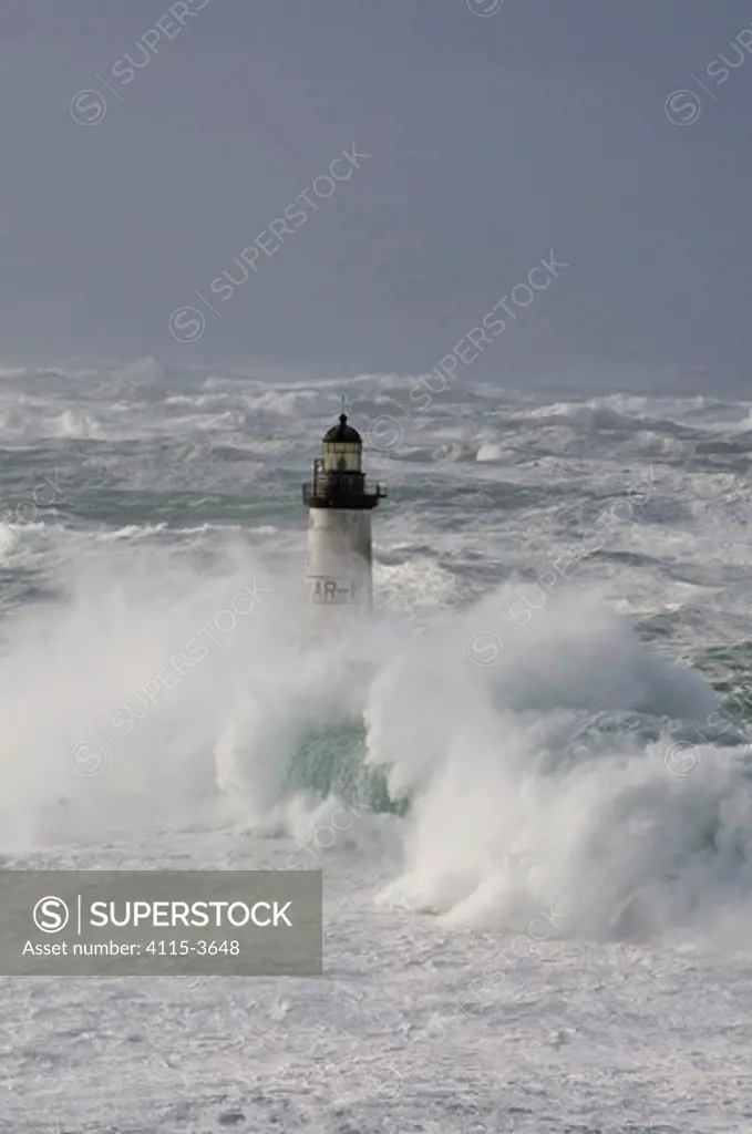 Waves crashing around Ar-Men Lighthouse (37 metres) in the Sein channel, Finistère, Brittany, France. December 2007.