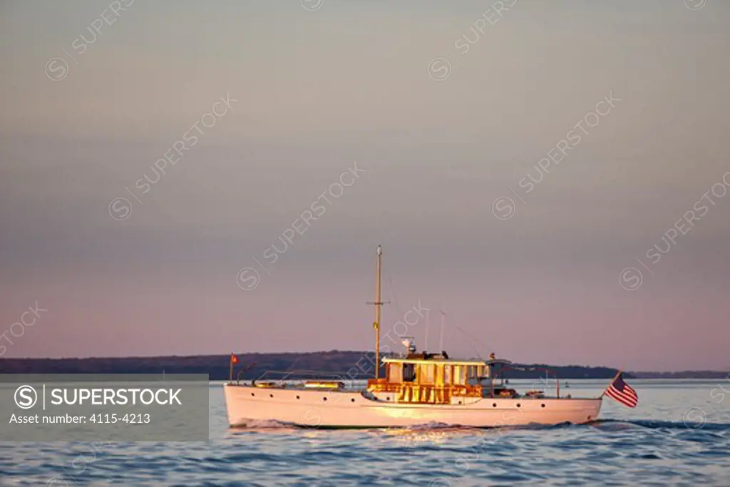 Restored classic powerboat 'Carina' in evening light off the coast of Newport, Rhode Island, USA, November 2010. All non-editorial uses must be cleared individually.