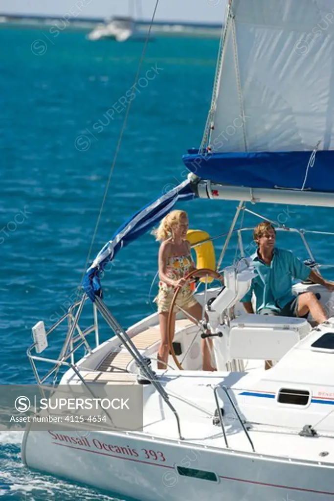 Couple helming a Sunsail yacht sailing in the British Virgin Islands, March 2006. Model and property released.