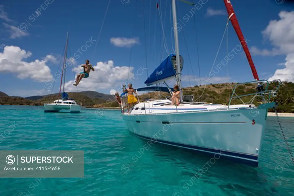 Man swinging from a line on a Sunsail yacht in the British Virgin Islands, March 2006. Model and property released.