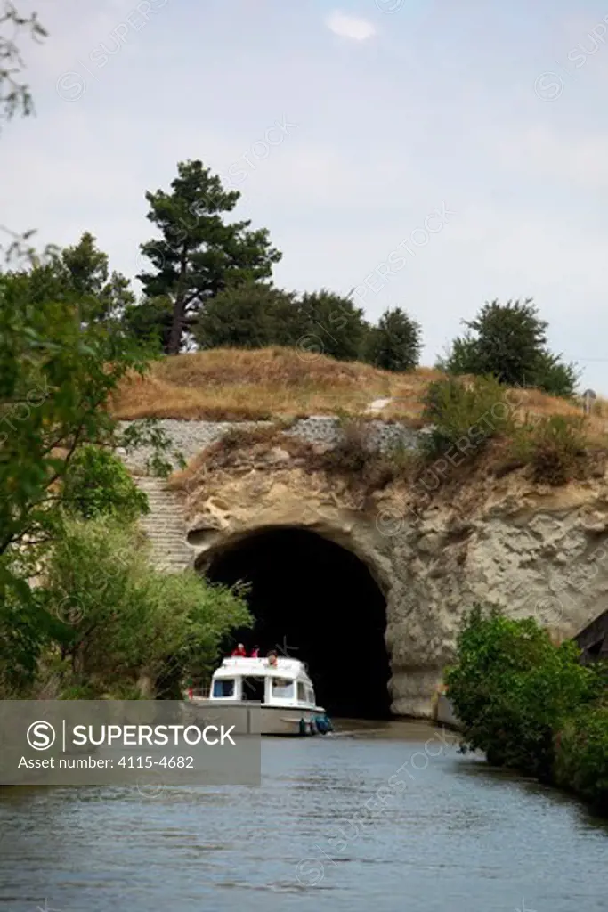 Boat passing through a tunnel on the Canal Du Midi near Capestang, Languedoc, France. July 2009. Model and property released.