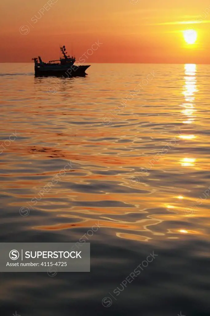 Trawling on the North Sea in calm conditions at sunset, May 2010. Property released.