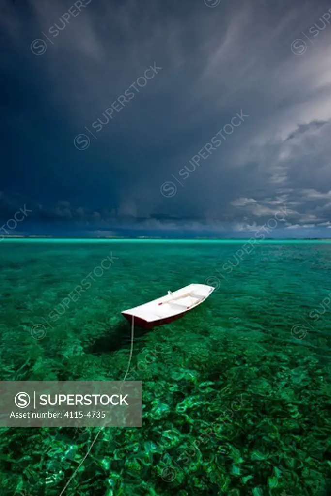 Tethered tender floating on clear waters under stormy skies. Exumas, Bahamas, Caribbean. June 2009.