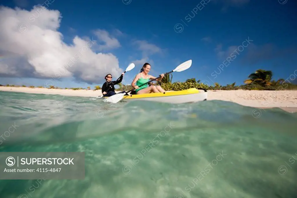 Two women kayaking, Sandy Island, near Carriacou Island, the Grenadines, Caribbean, January 2010. Model released.