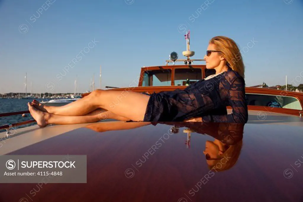 Woman relaxing on board luxury motorboat 'Aphrodite'. Newport, Rhode Island, USA, July 2010. Model and Property released.