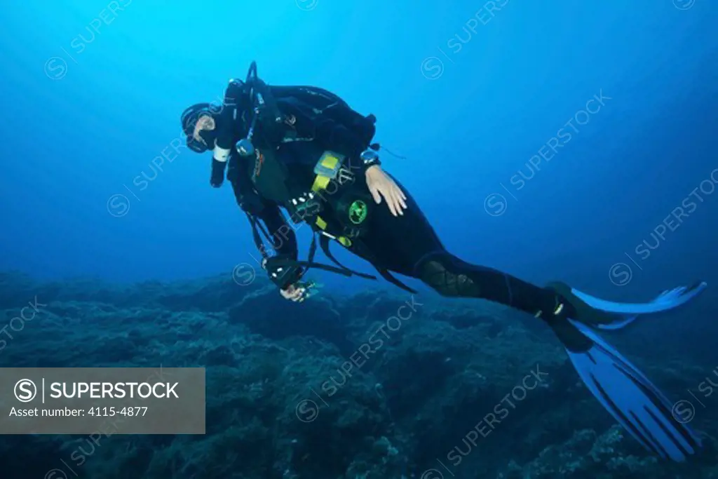 Rebreather diver swimming along the sea bed. Capraia, Tuscany, Italy, August. Model released.
