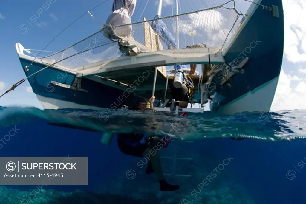 Diver entering the water from Glenn Edney's whale watching catamaran boat 'Cat Knapp', off Tonga, Melanesia, Pacific 2007