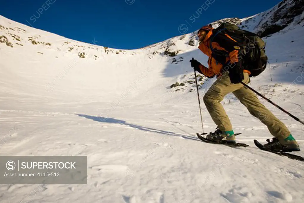 A man walking in snowshoes in Tuckerman Ravine, White Mountains, New Hampshire, USA