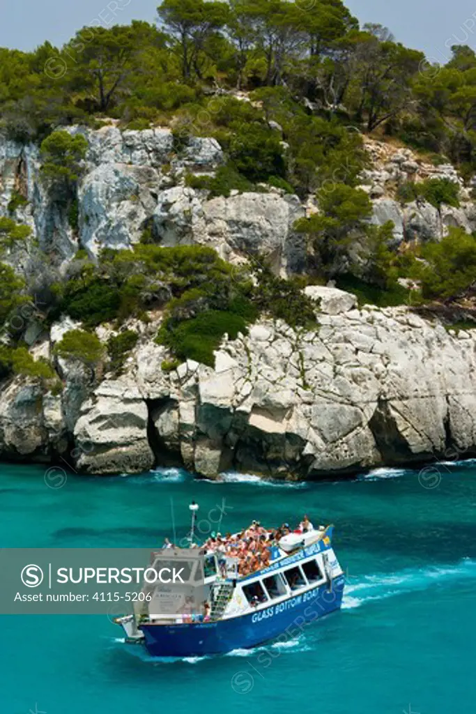Tourist boat passing the Rocky coast of Cala Macarella, Menorca, Balearic Islands, Spain, Mediterranean, July 2005