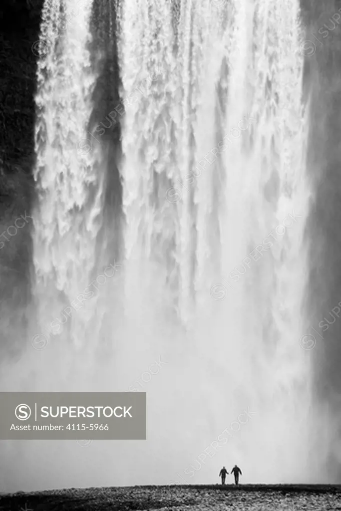 Two people silhouetted in front of Skogafoss waterfall in southern Iceland, June 2009
