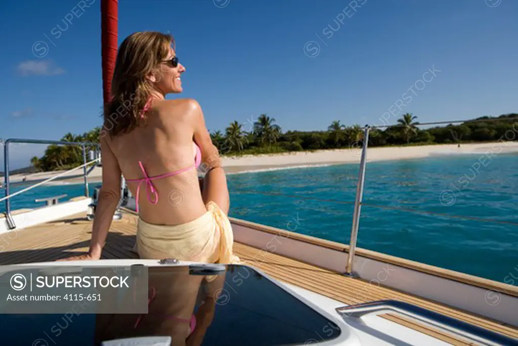 Woman relaxing on the bow of a Sunsail yacht in the British Virgin Islands, Caribbean
