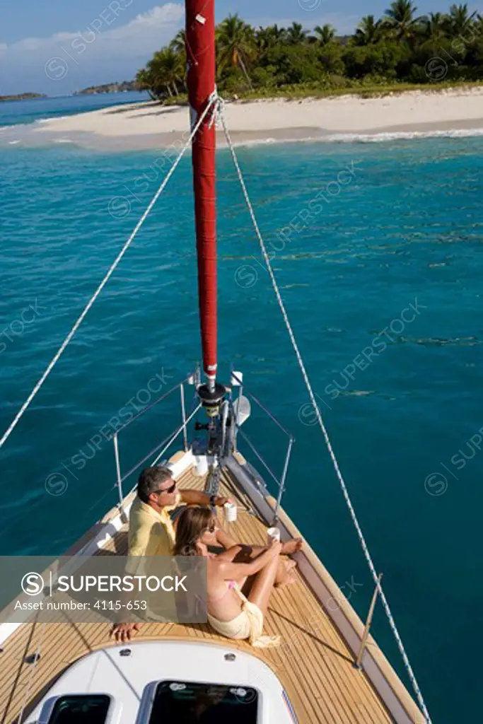 Couple relaxing on the bow of a yacht in the British Virgin Islands, Caribbean, March 2006.