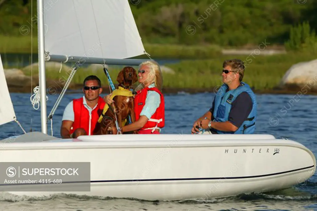 Friends and a dog sailing a Hunter 146 dinghy near Mystic, Connecticut, USA. August 2004.