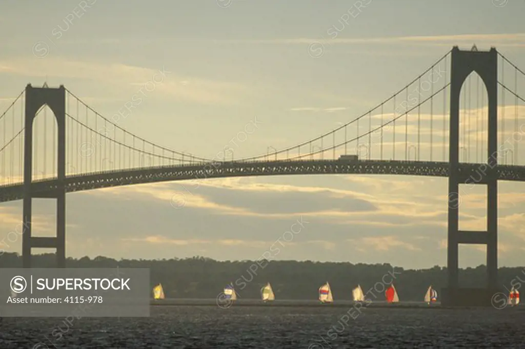 A fleet of Shields racing under the Newport Bridge during the weekly Thursday night series, Newport, Rhode Island, USA.