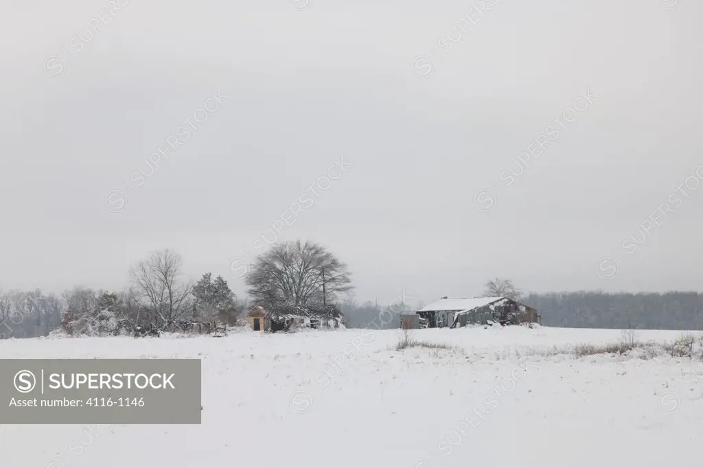 USA, Arkansas, Snow covered field, with house and barns