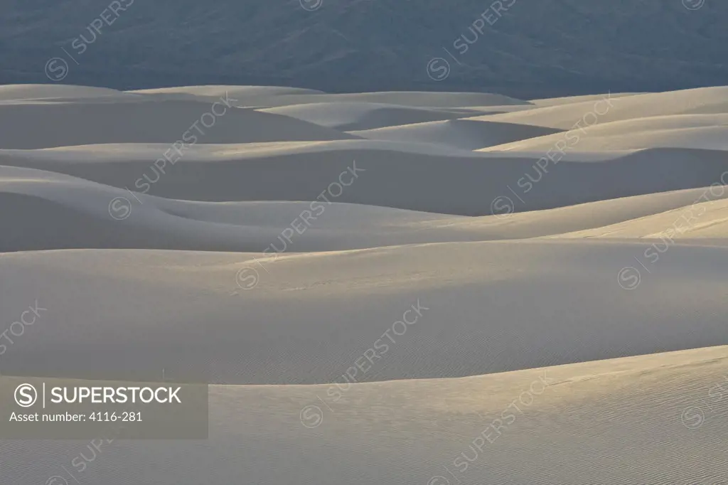 USA, New Mexico, White Sands National Monument, Sand dunes and mountains at sunset