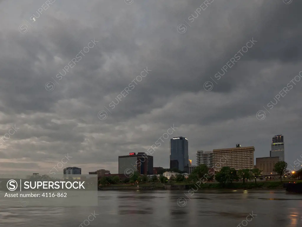 Little Rock skyline at dawn, with moon peaking through the clouds