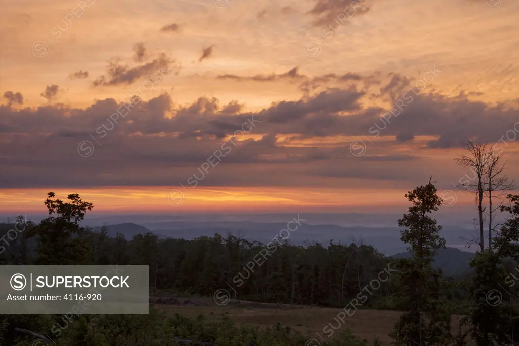 USA, Arkansas, Colorful sunrise sequence from hill, with silhouetted trees