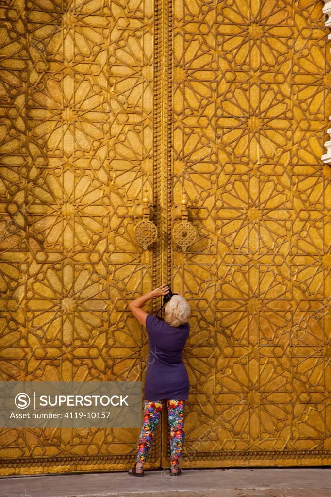 Photograph of a photographer takeing pictures of the golden gates of the royal palace in the city of Fes