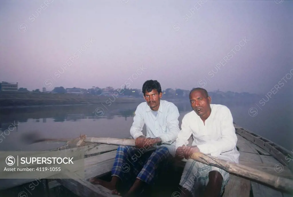Photograph of two Indian men rowing their boat on a river in India