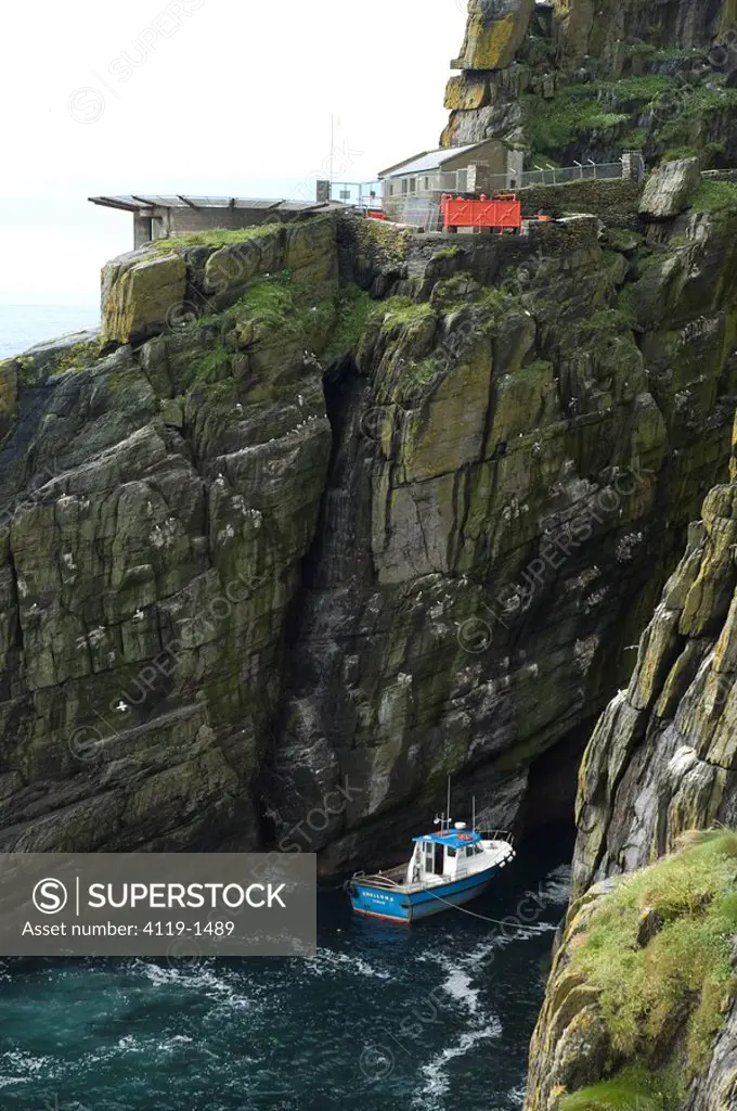 Photograph of a tied boat to a cliff in Ireland