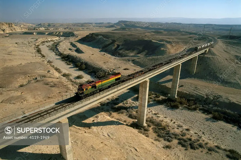 Aerial photograph of a train on a bridge above Zin river in the Negev desert