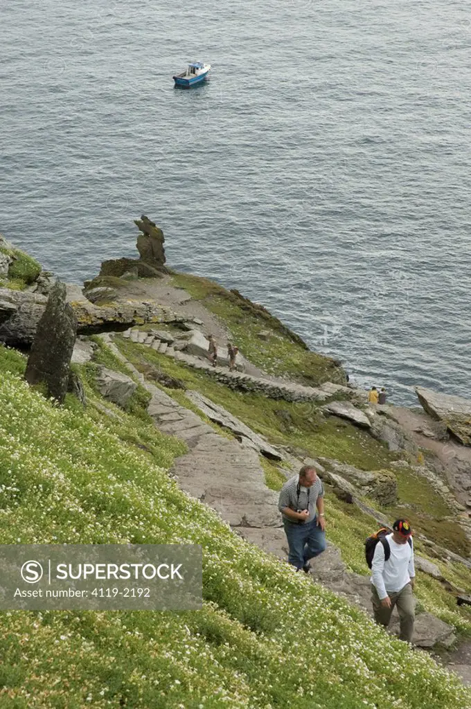 Photograph of two men walking up a cliff in Ireland