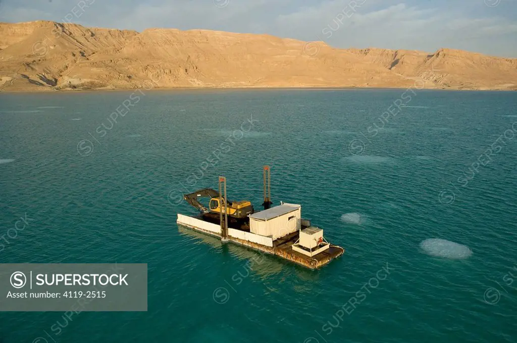 Aerial photograph of a crane on a barge in the southern basin of the Dead sea at sunrise