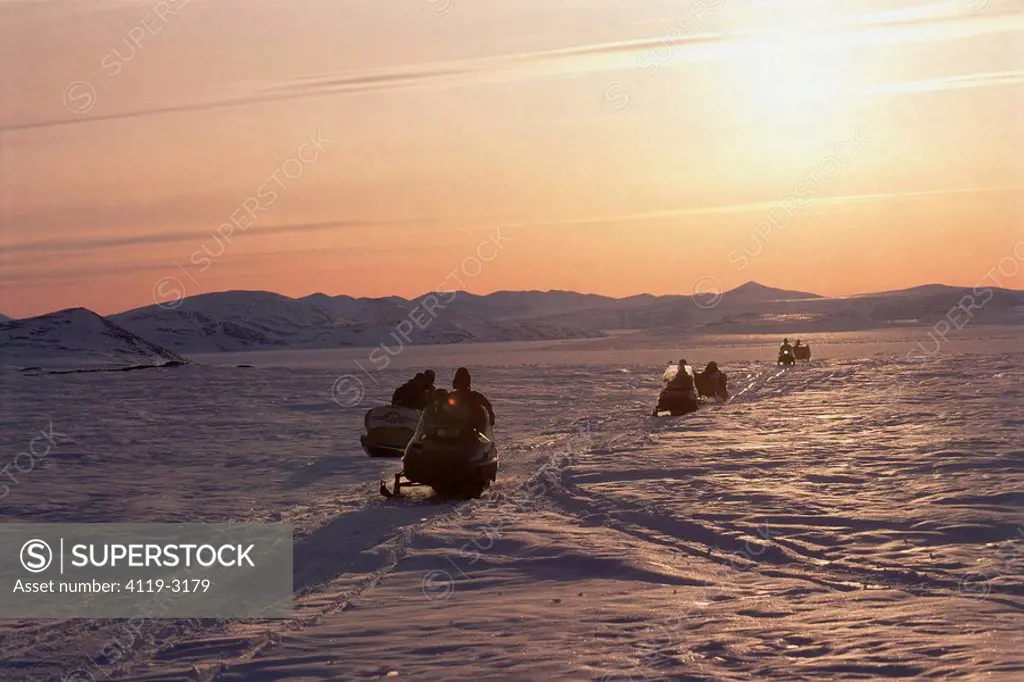 Image of a convoy of motorbikes on the ice plains of Baffin Canada