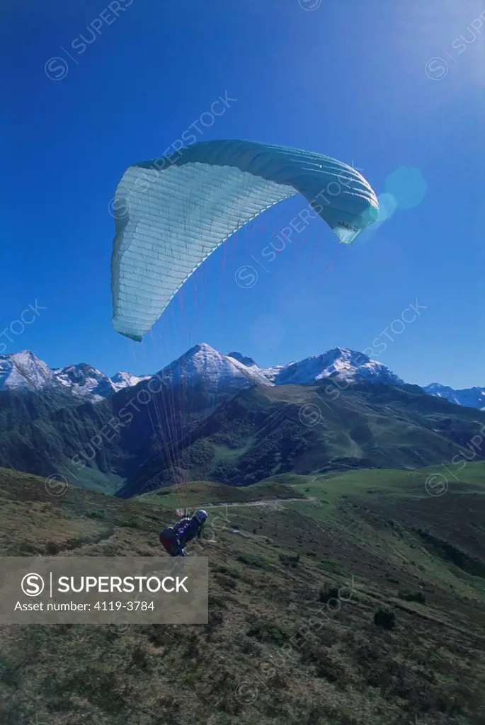 Photograph of a parachutist taking off from a mountain top in France