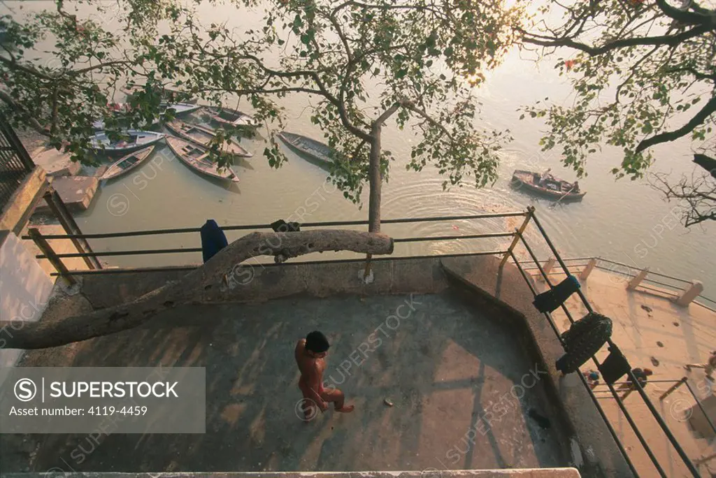 Photograph of an Indian man standing naked on a balcony in India