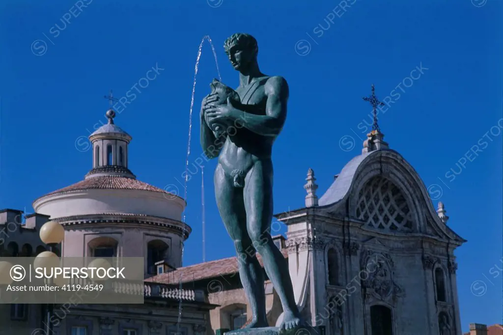 Photograph of a fountain in front of a church in a village in Italy