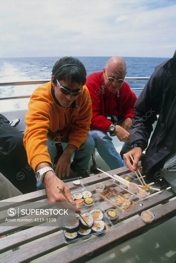 Photograph of couple of guys eating sushi on a boat in New Zealand
