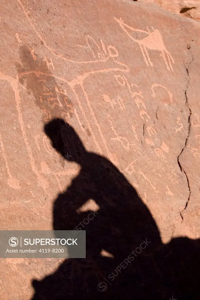 Photograph of a man´s shadow on a carved wall in the Jordanian desert