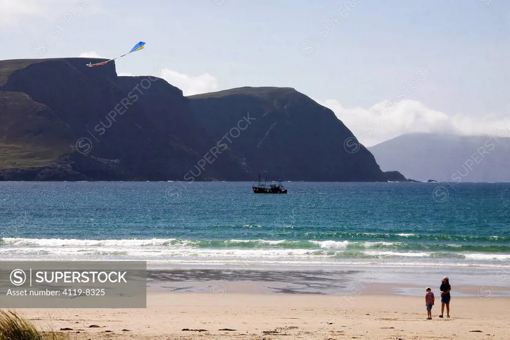 Photograph of a mother and her son flying a kite on a beach in Ireland