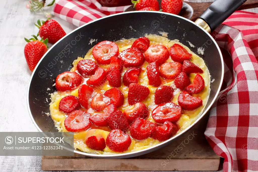 Strawberry omelette on frying pan. Party dessert