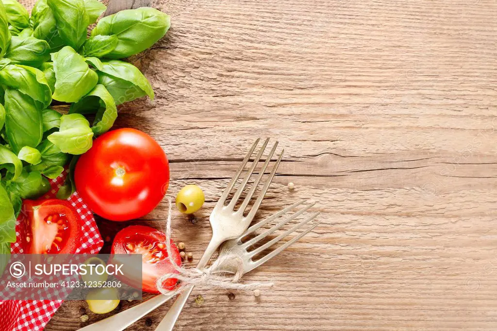 Italian cuisine background: tomatoes, olives and peppers on wooden table, copy space