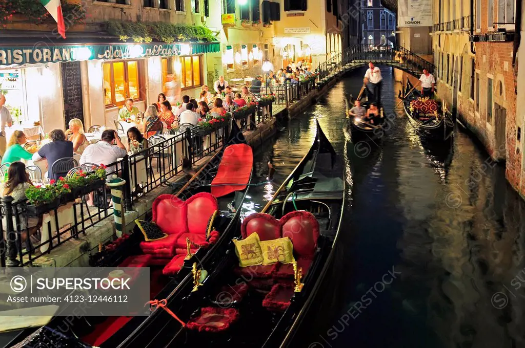 Small restaurant on venetian canal among old houses in Venice Italy.