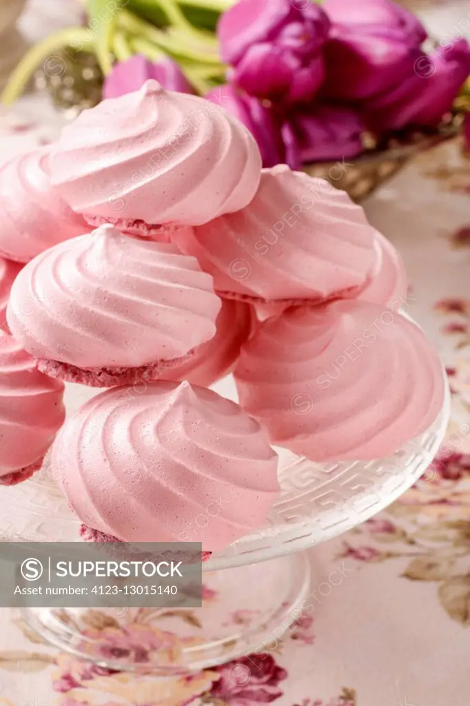 Pink meringues on cake stand. Party dessert