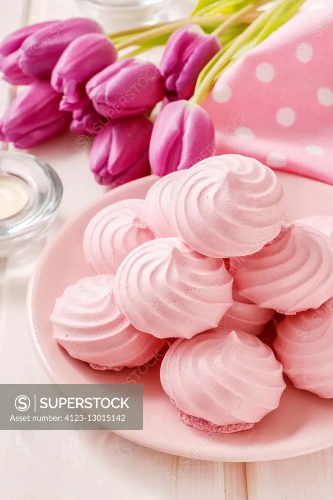 Pink meringues on cake stand. Party dessert