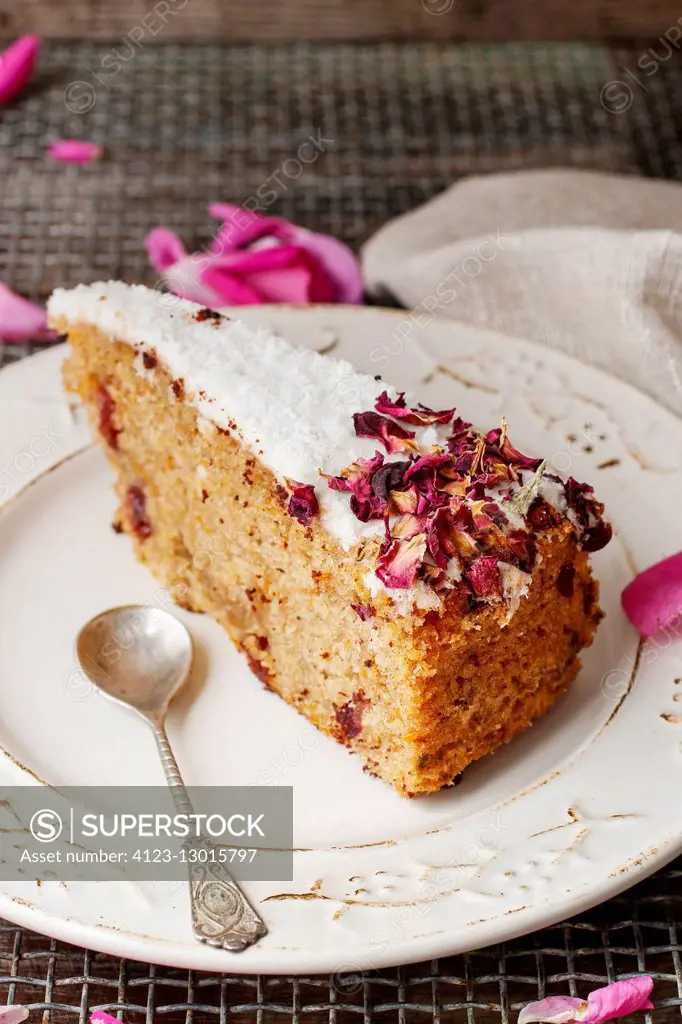 Carrot vegan cake with coconut icing and dried wild rose petals (rosa rugosa)