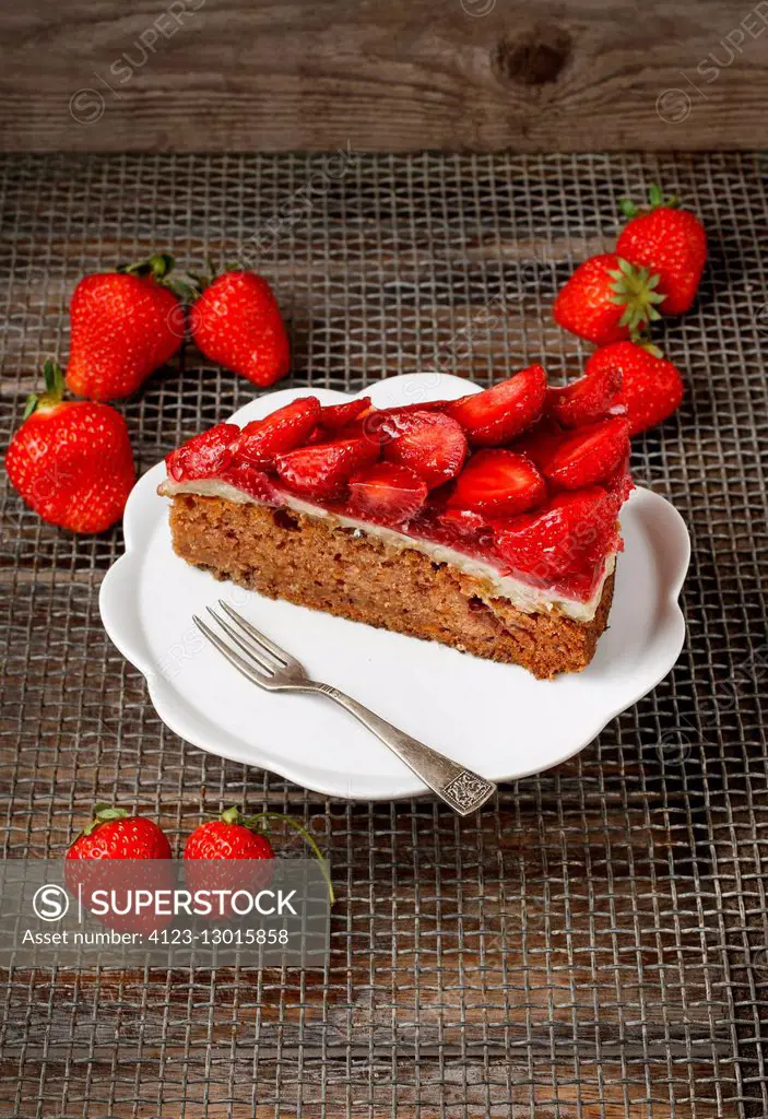 Piece of strawberry cake on white ceramic cake stand. Party dessert