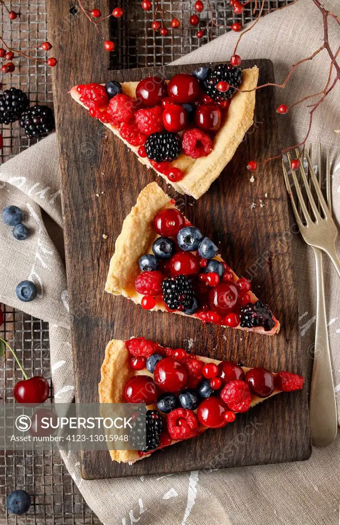 Sweet tart with raspberries, blueberries, blackberries, cherries and red currants. Party dessert