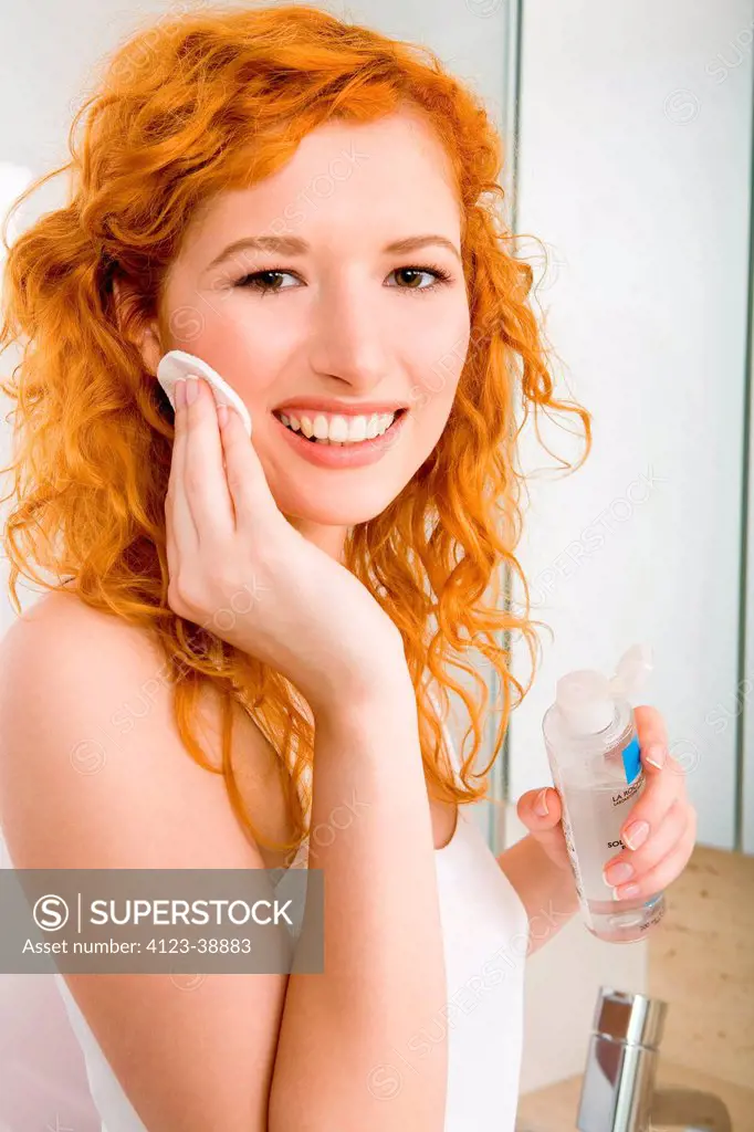 Young woman cleansing face.