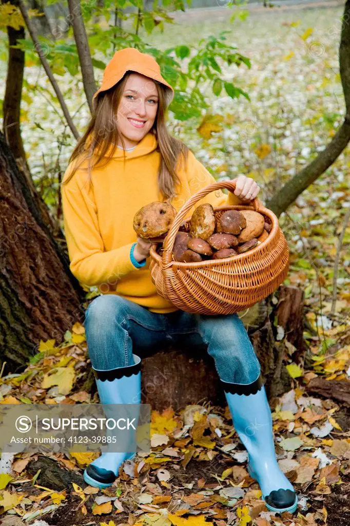 Woman picking up mushrooms in the forest.