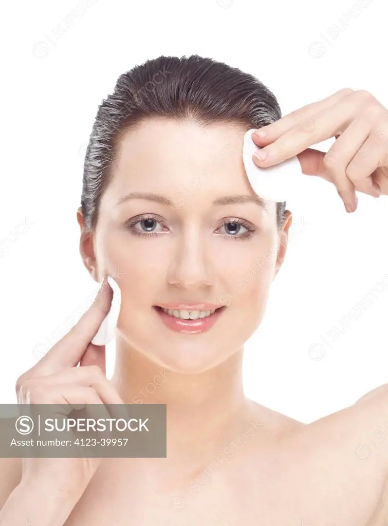 Woman cleaning her face with swab.