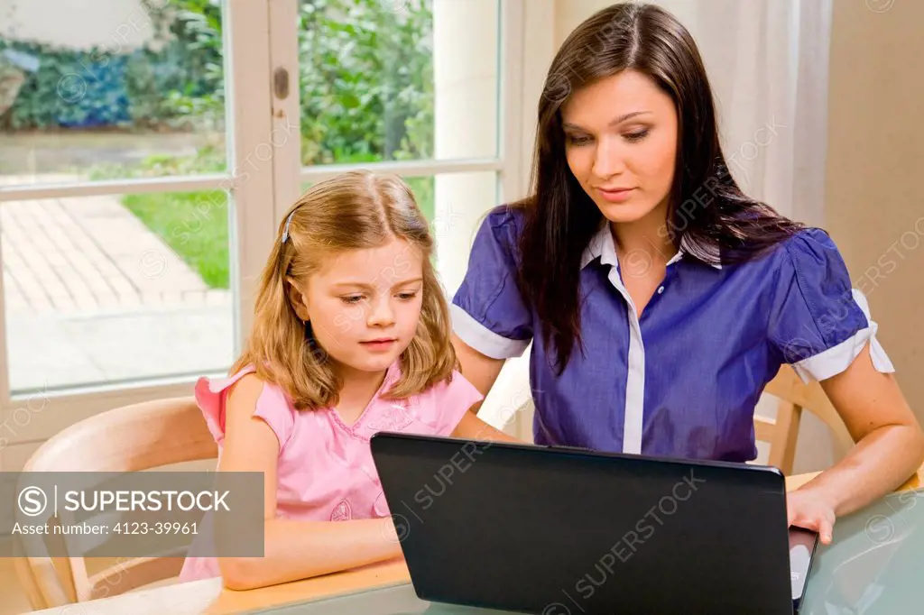 Woman and girl using laptop.