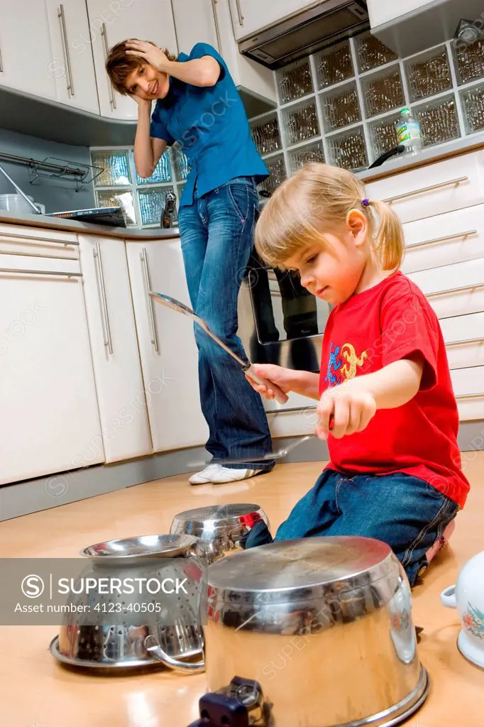 Girl drumming on pots with spatula.